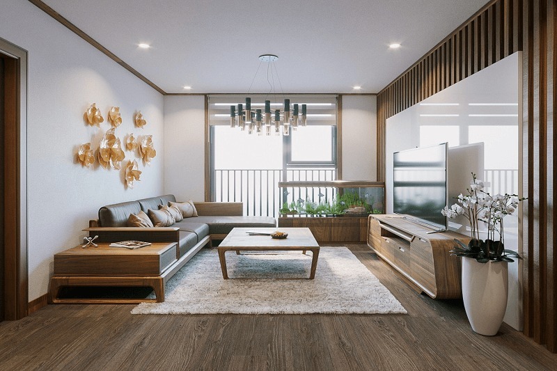 Phòng khách được bài trí đơn giản với hai mảng màu nâu và trắng, các bông hoa nhựa trang trí trên tường tạo điểm nhấn cho cả căn phòng