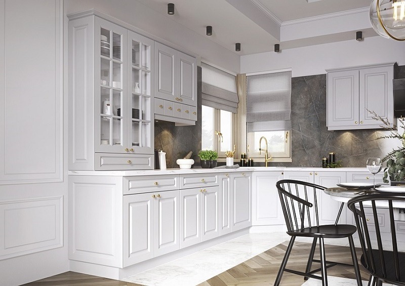 Góc bếp với gam màu trắng chủ đạo với tâm điểm là hệ tủ bếp hình chữ L sử dụng tay nắm màu vàng đồng tinh xảo gợi lên bầu không khí Tân cổ điển